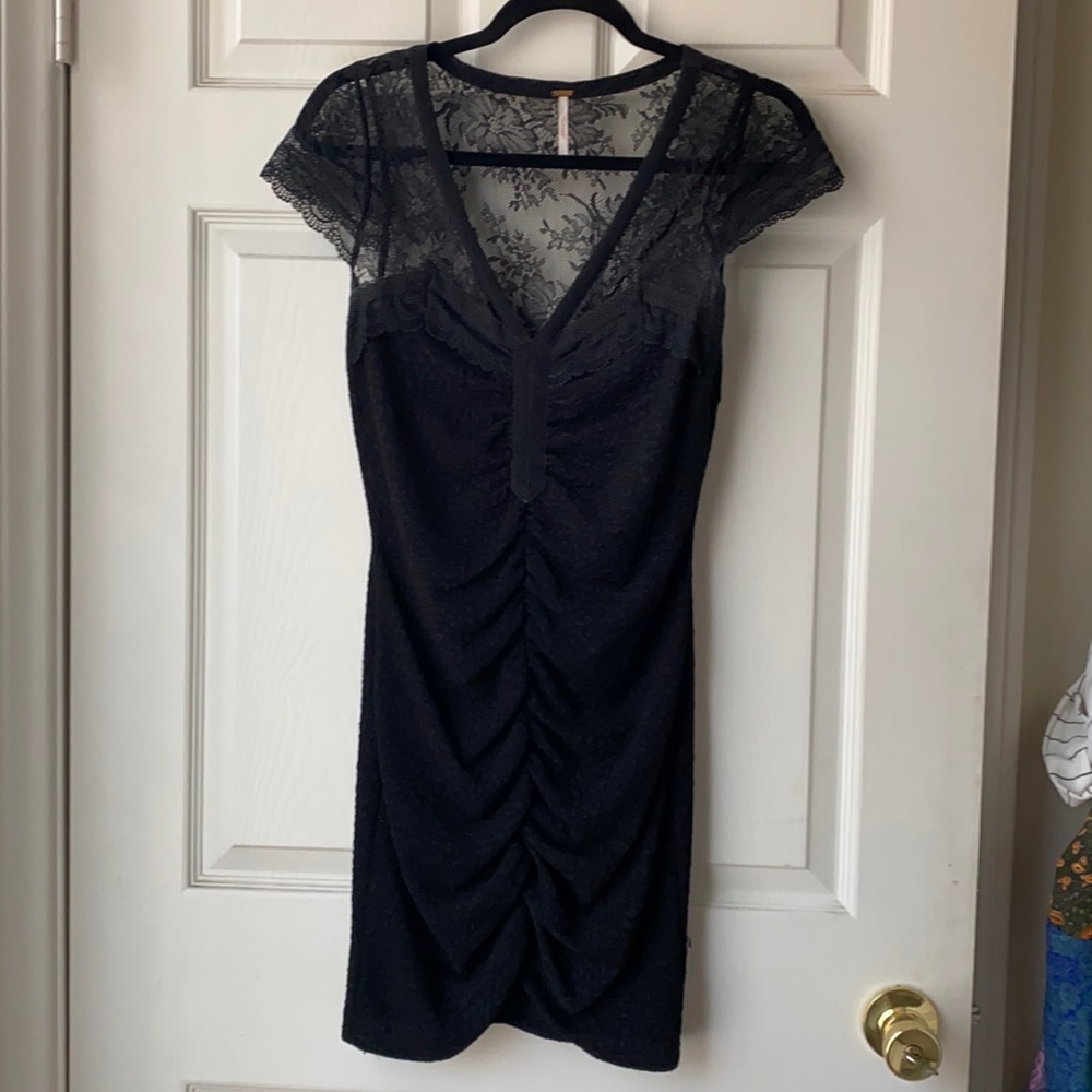 Black fitted mini dress with cinched front.